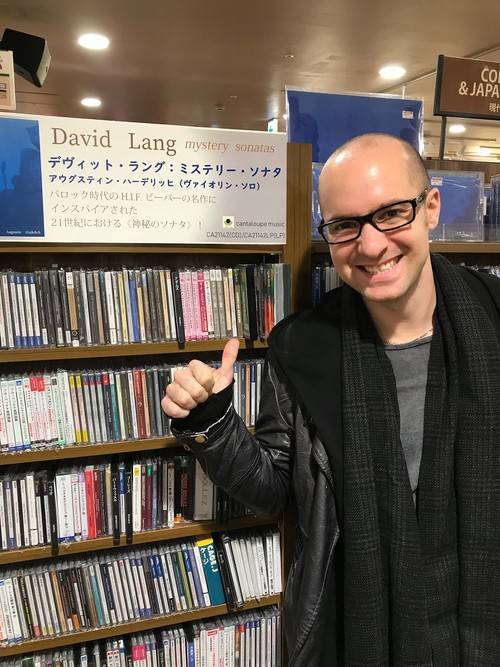 Adam Cuthbert posing in front of CDs in a store